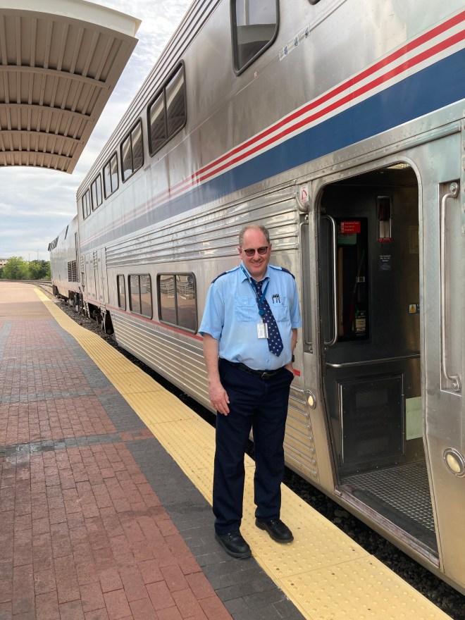 Train crew stands outside train